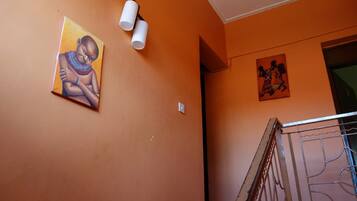 Una escalera con barandillas metálicas y una pared con dos obras de arte.