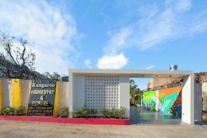 A building entrance with a sign for 'Kangaroo Homestay & Coffee' and a colorful mural on the wall.
