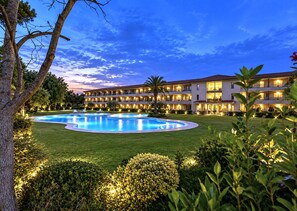 A hotel with a swimming pool, multiple balconies, and well-lit outdoor areas. - Coastal Family Apartment With Pool (Pals)