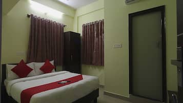 Habitación de hotel con cama, armario, puerta y unidad de aire acondicionado.