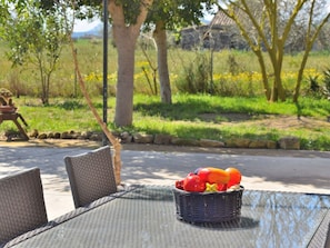 A wicker table with a basket containing fruit and vegetables. - Cabin in Sineu With Swimming Pool (Sineu)