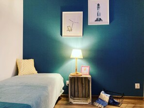 A bedroom with a bed, a nightstand with a lamp, and two framed pictures on the wall. - Holiday Home for 4 People, Dziwnow (Dziwnów)