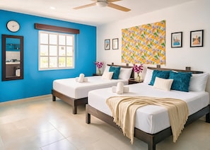 A hotel room with two beds, a large window, a ceiling fan, and a colorful tapestry. - Sleeps 4, Fiber-Optic WiFi, AC, Laundromat Next Door, Market 10 Min Walk (Playa del Carmen)