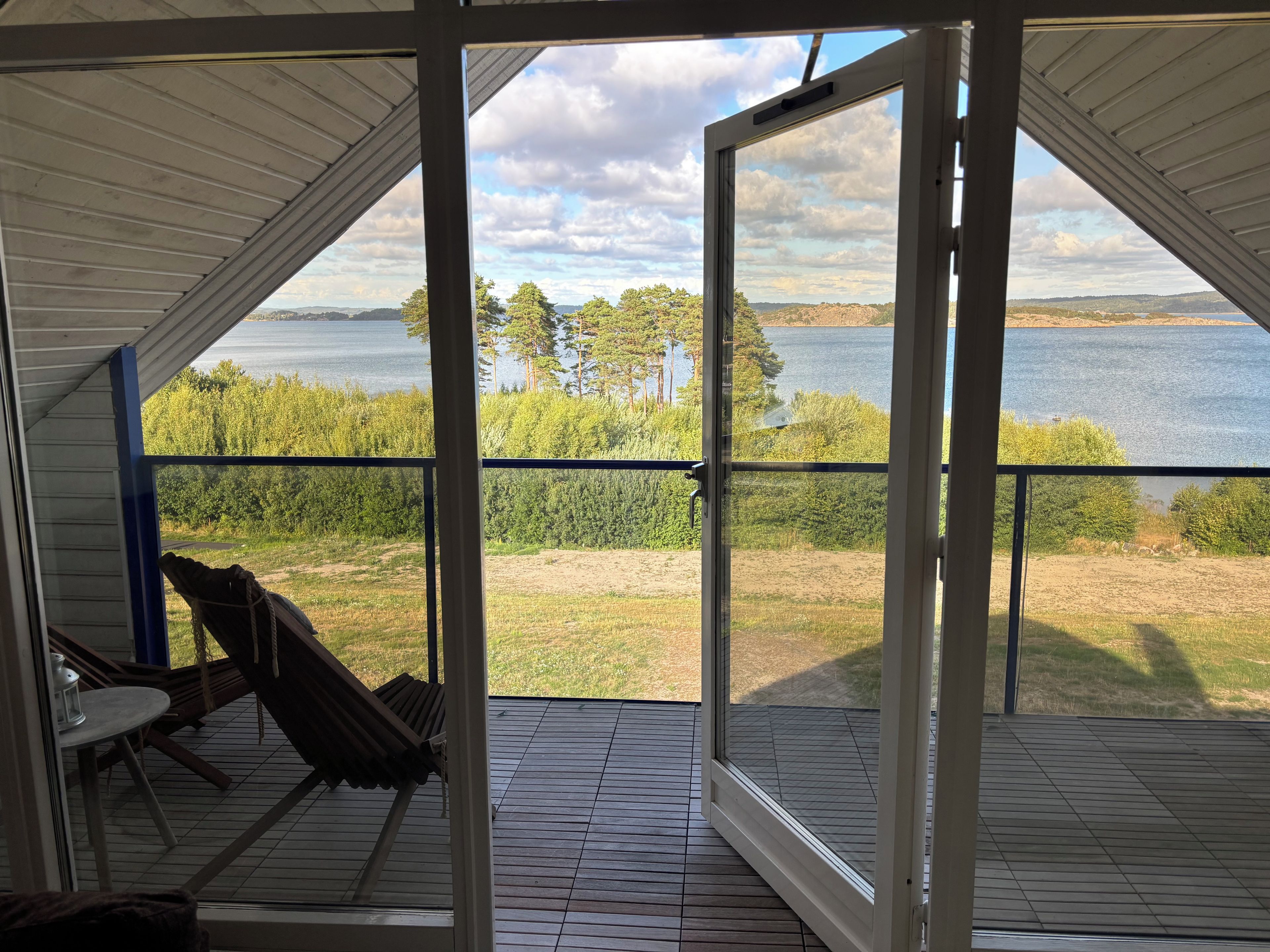Un espace extérieur abrité offrant une vue sur un lac et des arbres.