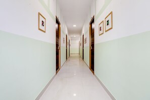 Corredor com portas em ambos os lados, dando acesso a quartos individuais.