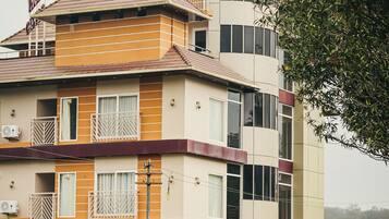 Un hotel de varios pisos con un estilo arquitectónico particular, que combina balcones y grandes ventanales.