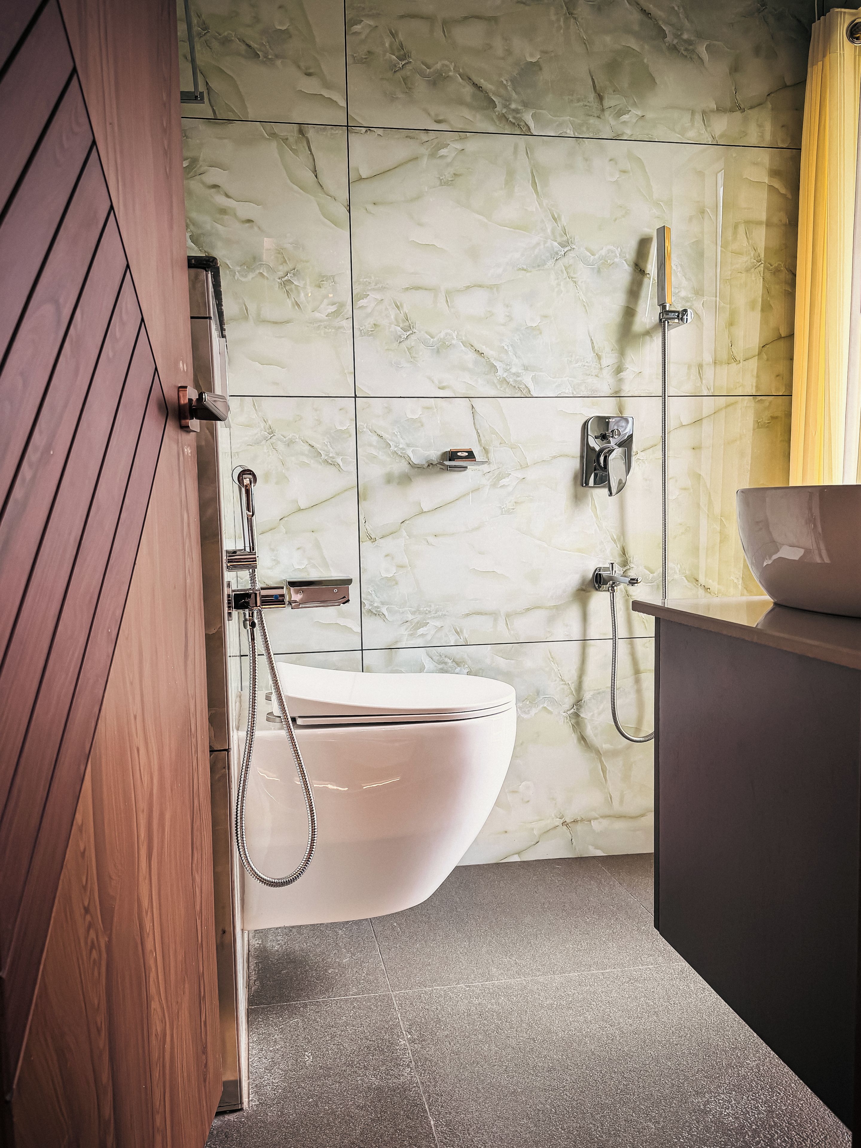 Un baño con inodoro blanco, ducha y lavamanos.