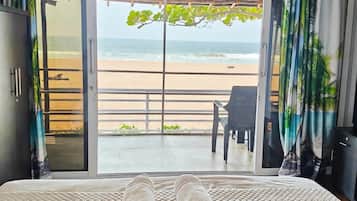 Una cama con toallas, vistas a la playa y techo de madera.