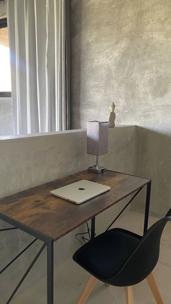 A room with a wooden desk, a laptop, a lamp, a chair, and a window with curtains. - Modern Loft - Spectacular Mountain and Lake Views (Valle de Bravo)