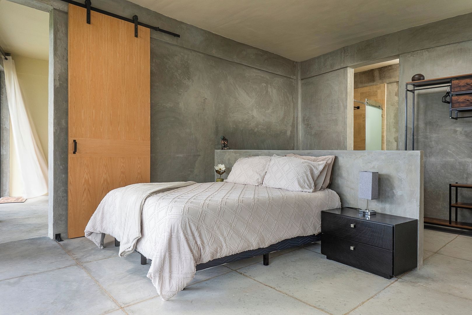 A bedroom with a bed, bedside table, and a wardrobe.