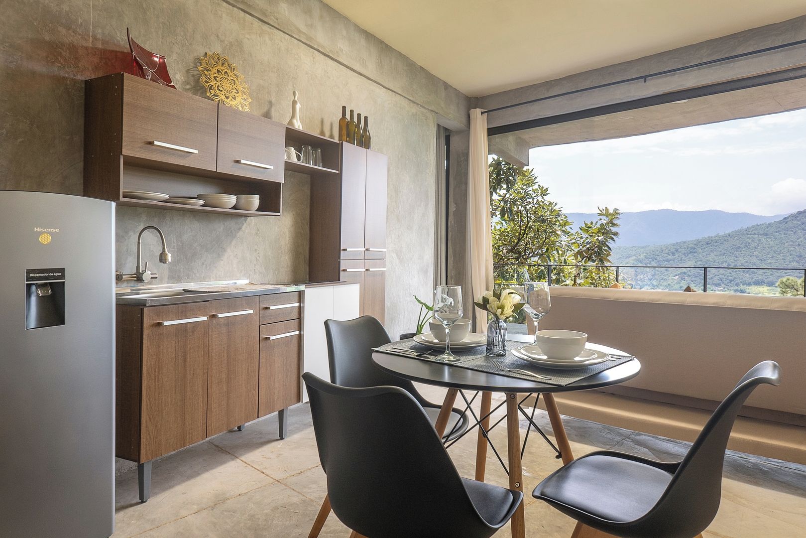 A modern kitchen with a built-in refrigerator, wooden cabinets, and a dining area with a glass table and chairs.