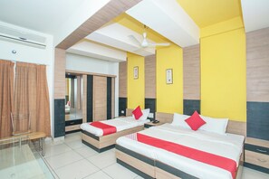 Habitación de hotel con dos camas, un escritorio y una silla.