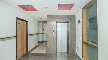 Un pasillo con una puerta marcada '301', un extintor y un interfono instalado en la pared.
