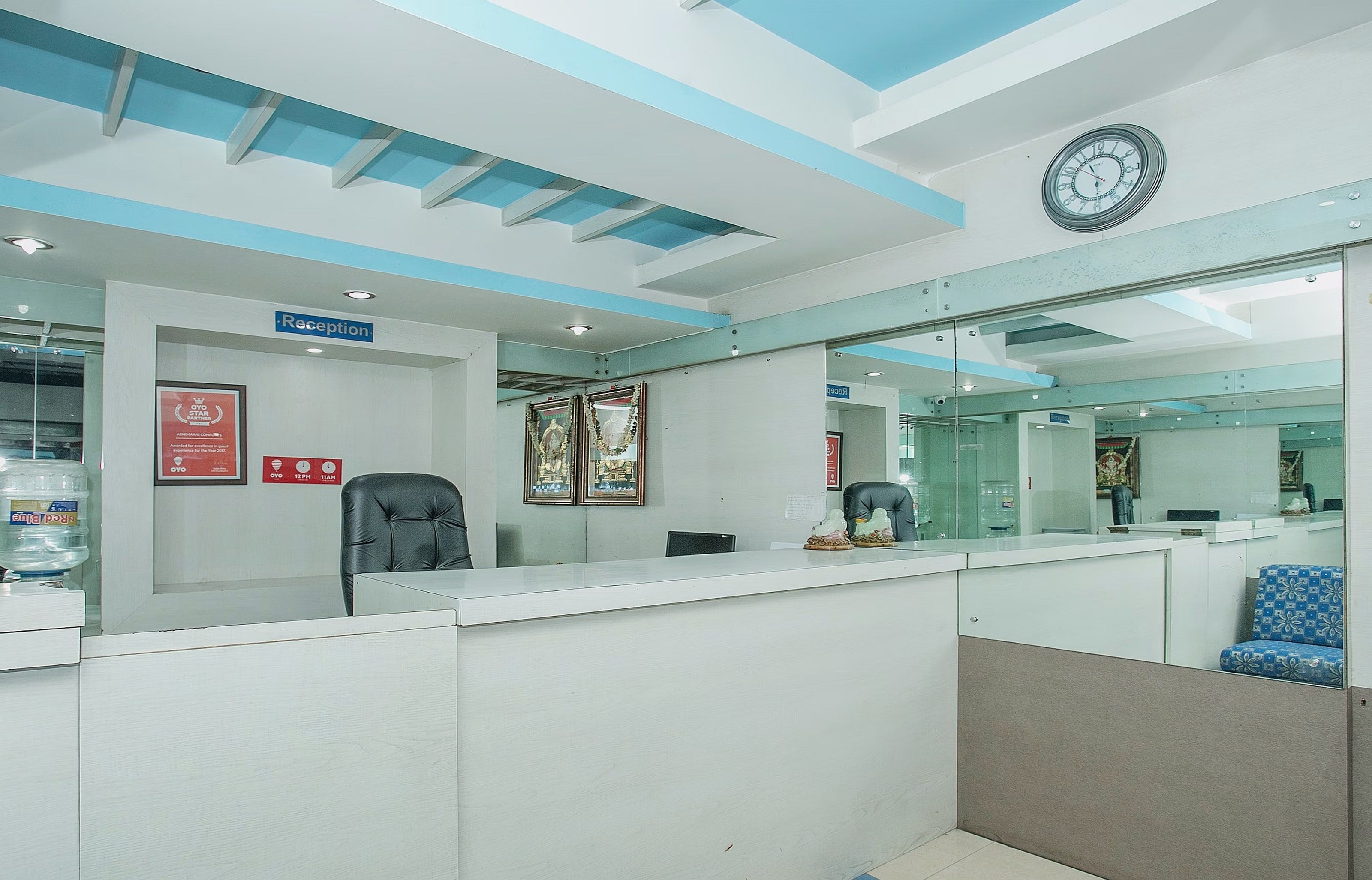 A reception area with a reception desk, a clock, and a water dispenser.