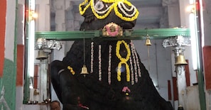 Un temple amb una gran estàtua de bou, campanes i decoracions florals.