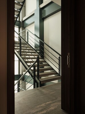 A modern staircase with metal railings and a dark wooden door. - Condesa Residence - Roma Luxury Suite 407 (Ciudad de México)