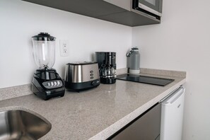 A kitchen with a blender, toaster, coffee maker, and a water dispenser on the counter. - Condesa Residence - Roma Luxury Suite 407 (Ciudad de México)
