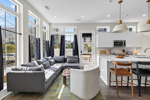 A modern apartment with a living room, kitchen, and dining area. - 4 Modern Townhomes | Balconies | Walk to Cafés + Shops | Lischey Full Buyout (Nashville)