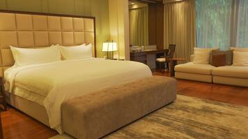 Une chambre d’hôtel avec un grand lit, un canapé, un bureau et une chaise.