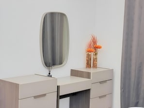 A modern bathroom vanity with a mirror, two drawers, and a vase with dried flowers. - Rooftop Pool with Riverview 3 bedroom apartment (Kinshasa)