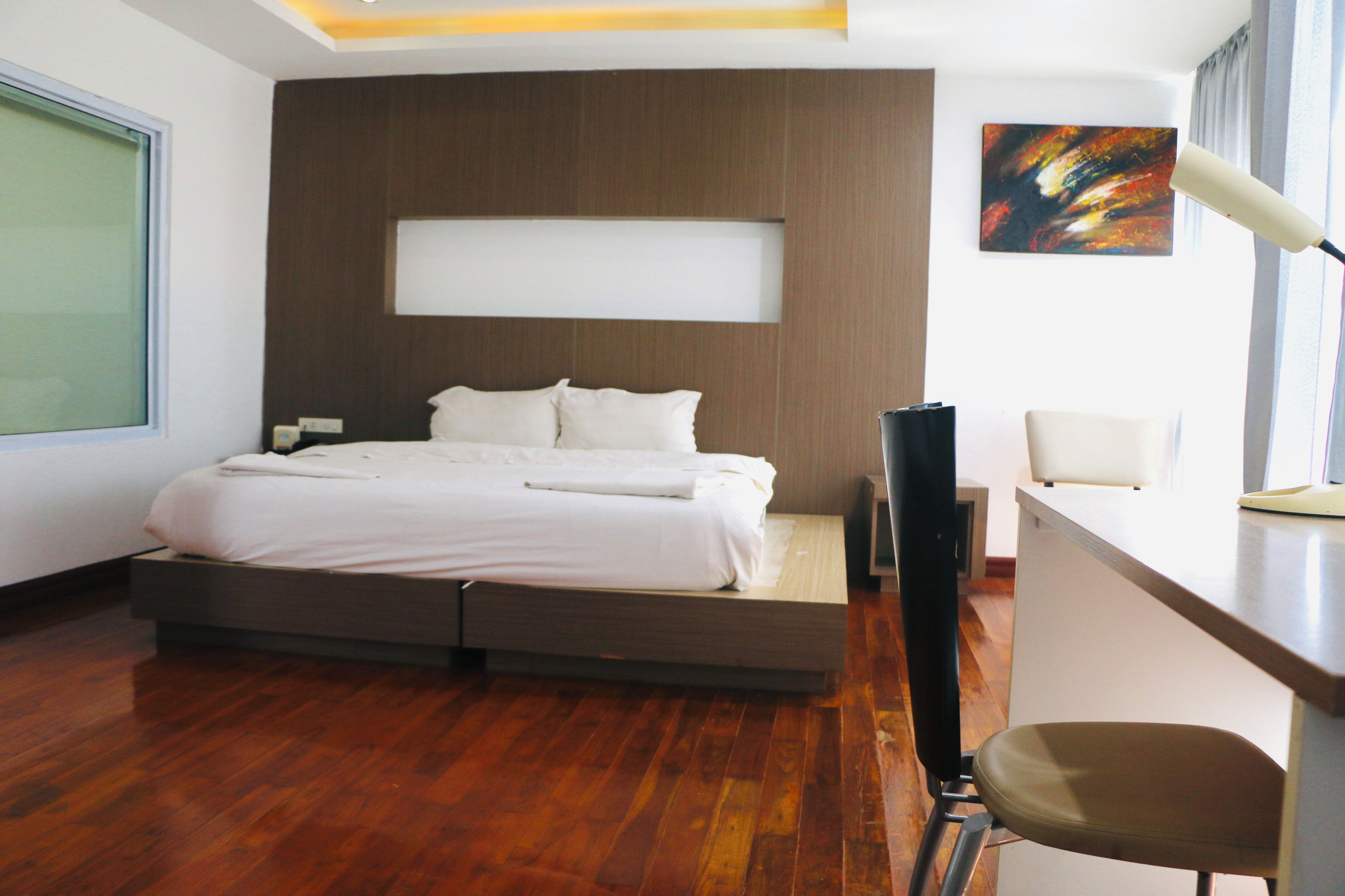 A modern bedroom with a bed, a desk, and a chair.