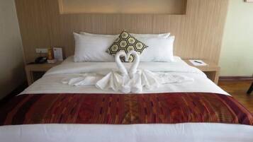 Una habitación de hotel con una cama, una mesita de noche y una estantería en la pared.