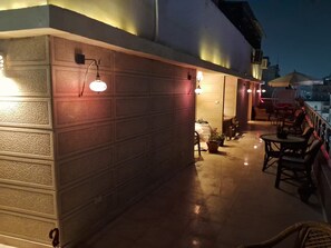 An outdoor patio area with a concrete floor, potted plants, and outdoor furniture. - 15 Bustan Downtown 
Timeless class, modern comfort (Cairo Governorate)