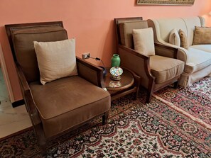 A room with a brown leather sofa, a patterned rug, and a small table with a green vase. - 15 Bustan Downtown 
Timeless class, modern comfort (Cairo Governorate)
