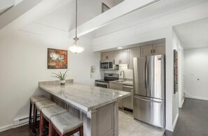 A modern kitchen with a central island, stainless steel appliances, and a pendant light. - Lodge at Mtn Village A303 | Ski-In/Ski-Out | PCMR Base | Pool | Hot Tub | Mtn Views | Fireplace (Park City)