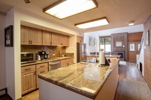 A modern kitchen with granite countertops, wooden cabinets, and built-in appliances. - Park Ave 216 | Heated Pool | Hot Tub | ¼ Mile to PCMR | Next to Golf Course | Walk to Shops (Park City)