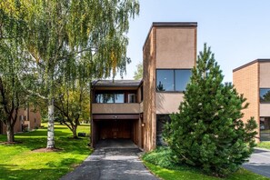 A modern building with a flat roof, a garage entrance, and a well-maintained lawn with trees. - Park Ave 236 | Heated Pool | Hot Tub | Mtn Views | Trail-Side by Golf Course | Laundry | Near PCMR (Park City)