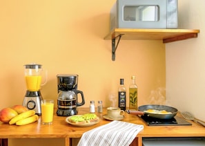 Eine Küche mit Mixer, Kaffeemaschine und Bratpfanne auf der Arbeitsfläche.