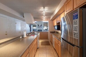 A modern kitchen with a stainless steel refrigerator, wooden cabinets, and a tiled backsplash. - Park Ave 251 | Heated Pool | Hot Tub | Vaulted Ceilings | Fireplace | Laundry | Near PCMR (Park City)