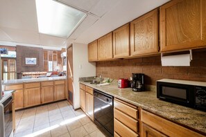 A kitchen with wooden cabinets, a dishwasher, a microwave, and a coffee maker. - Park Ave 267 | Heated Pool | Hot Tub | A/C | Cedar Accents | Laundry | Walk to Dining | Free Bus (Park City)