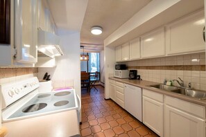 A kitchen with white cabinets, a stove, and a microwave. - Park Ave 268 | Heated Pool | Hot Tub | Fireplace | Trail-Side | Walk to Dining | Free Bus (Park City)