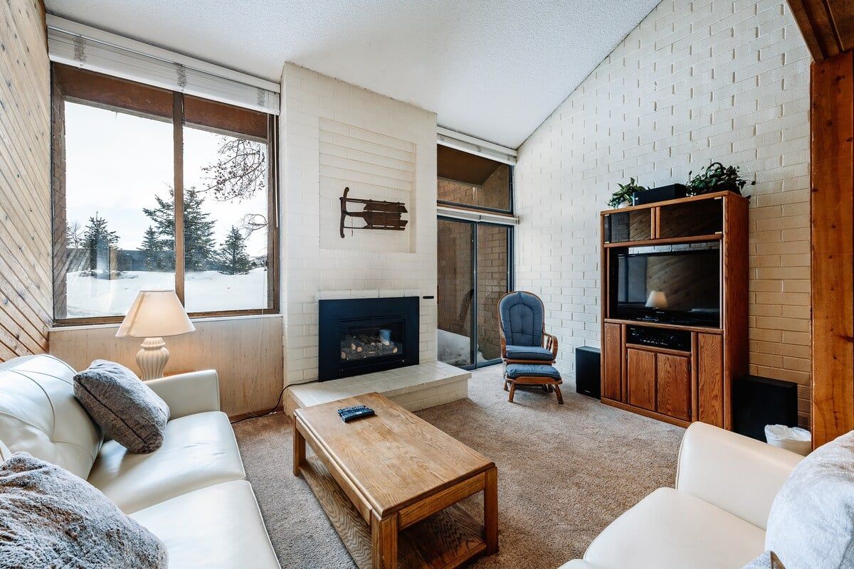 A cozy living room with a fireplace, a television, and a comfortable seating area.