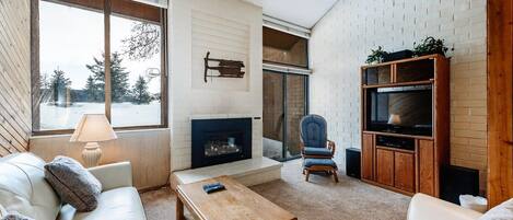 A cozy living room with a fireplace, a television, and a comfortable seating area.