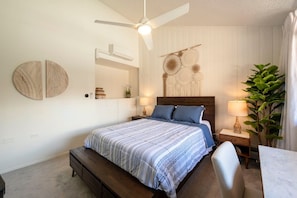 A bedroom with a bed, bedside tables, a ceiling fan, a wall-mounted air conditioner, and a large plant. - Park Ave 299 | Heated Pool | Hot Tub | Remodeled End Unit | Fire Table Atrium | Patio & Grill (Park City)