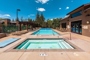 A pool area with two separate pools, lounge chairs, and a covered seating area. - Park Ave 314 | Heated Pool | Hot Tub | Fireplace | Laundry | Trail-Side | Near PCMR (Park City)