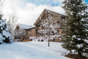 A two-story house with a snow-covered lawn and trees. - Jupiter Inn 10 | Community Hot Tub | Gas Fireplace | A/C | Laundry | Walk to Dining | Free Bus (Park City)