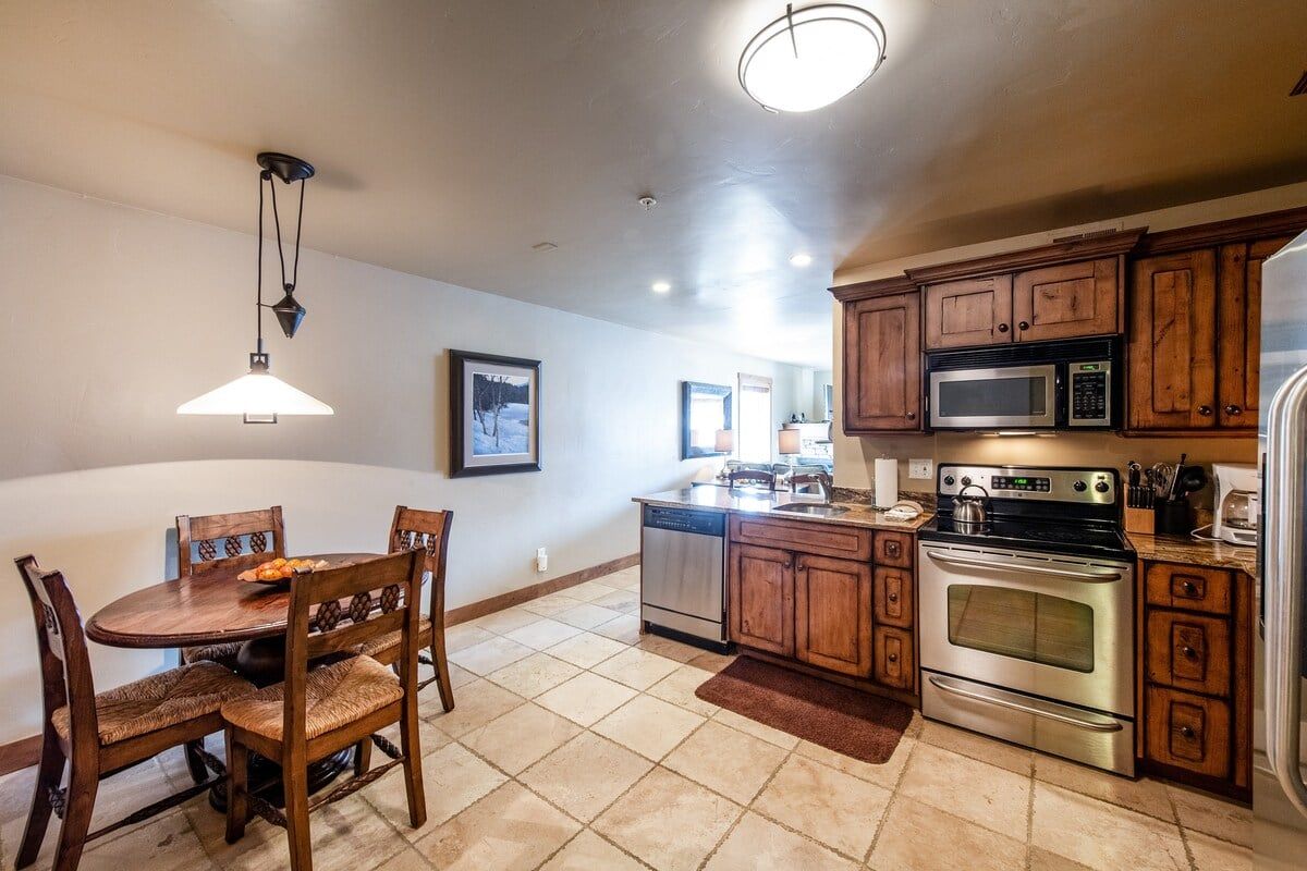 A kitchen with wooden cabinets, a stainless steel dishwasher, a microwave, and an oven.
