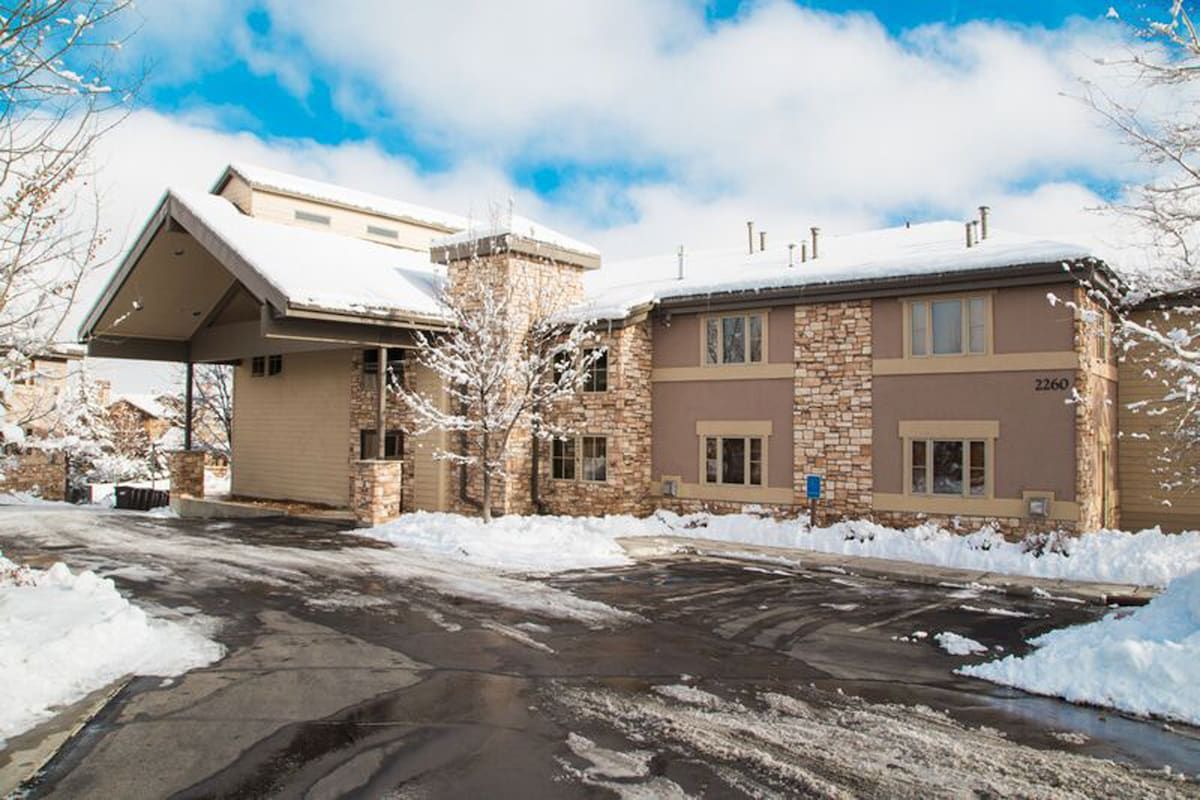 A two-story building with a stone facade and a snow-covered roof.