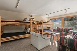 Ein Zimmer mit Etagenbetten, einer Schlafcouch und einem Sessel.