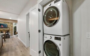 Uma lavanderia com duas máquinas de lavar roupa empilhadas.