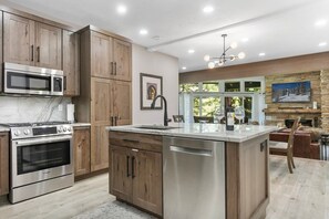 A modern kitchen with wooden cabinets, stainless steel appliances, and a central island.