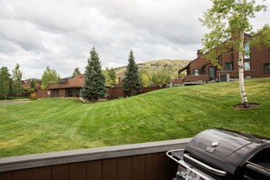 A residential area with a well-maintained lawn, a barbecue grill, and houses with modern architecture. - Three Kings 41 | Walk to Three Kings Lift | Heated Pool | Hot Tub | Sauna | Updated | Free Bus (Park City)