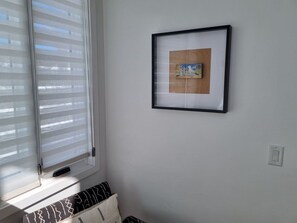 A room with a window with blinds, a framed picture on the wall, and a small white object on the wall. - Three Kings 80 | Walk to Three Kings Lift | Heated Pool | Hot Tub | Remodeled | Original Artwork (Park City)