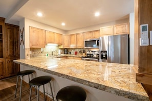 A kitchen with wooden cabinets, a granite countertop, stainless steel appliances, and a built-in microwave. - Resort Center 5002 | Ski-In/Ski-Out | Pool & Hot Tub Access | Fireplace | A/C | Granite Kitchen (Park City)