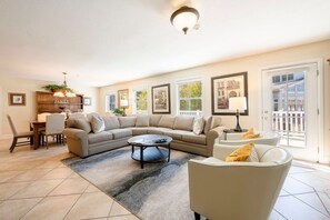 A living room with a sectional sofa, a round coffee table, and a dining area with a wooden buffet. - Resort Center 5004 | Ski-In/Ski-Out | Pool & Hot Tub Access | Fireplace | Elevator | 1,700 Sq Ft (Park City)