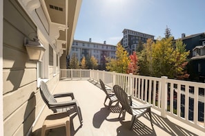 A balcony with outdoor furniture, a white railing, and a view of buildings and trees. - Resort Center 5004 | Ski-In/Ski-Out | Pool & Hot Tub Access | Fireplace | Elevator | 1,700 Sq Ft (Park City)